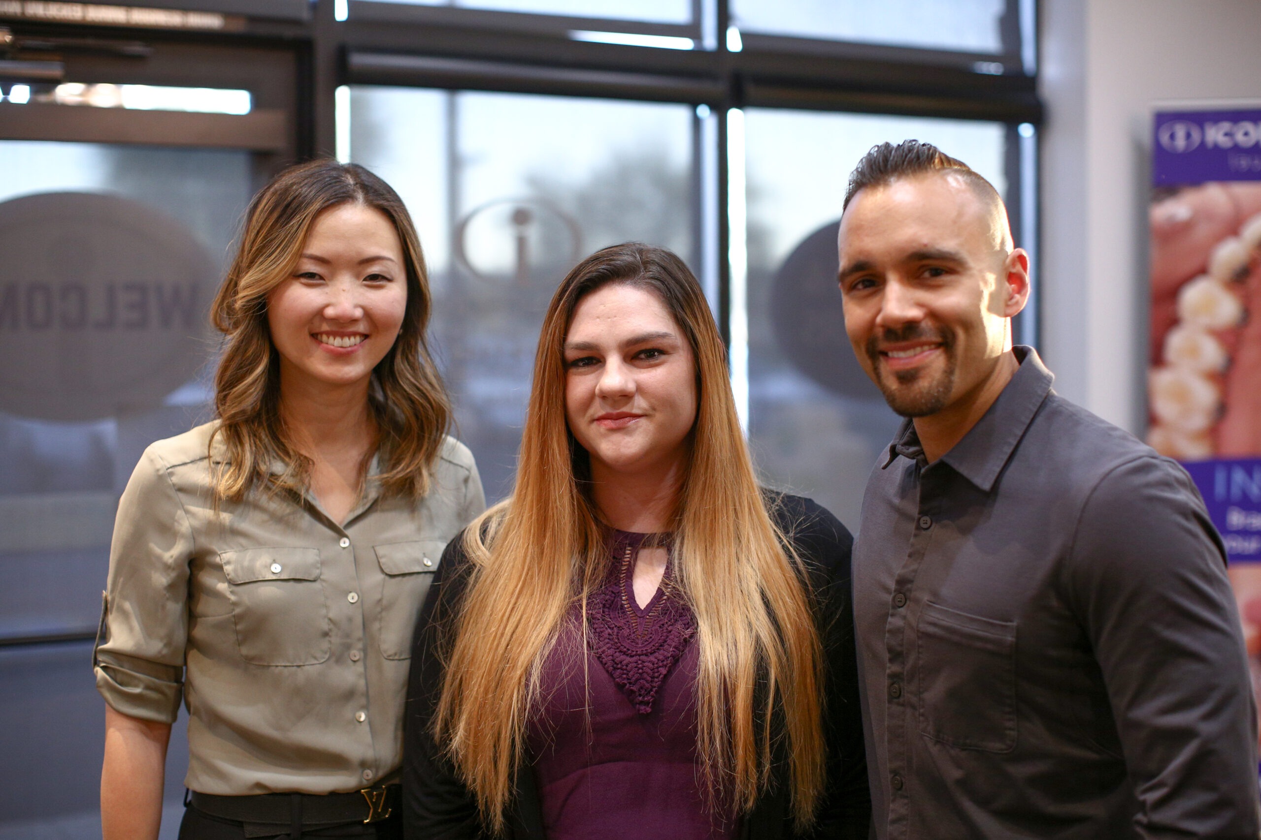 Three smiling individuals posing together in an orthodontic office, promoting discreet orthodontic options for adults at Icon Orthodontics.